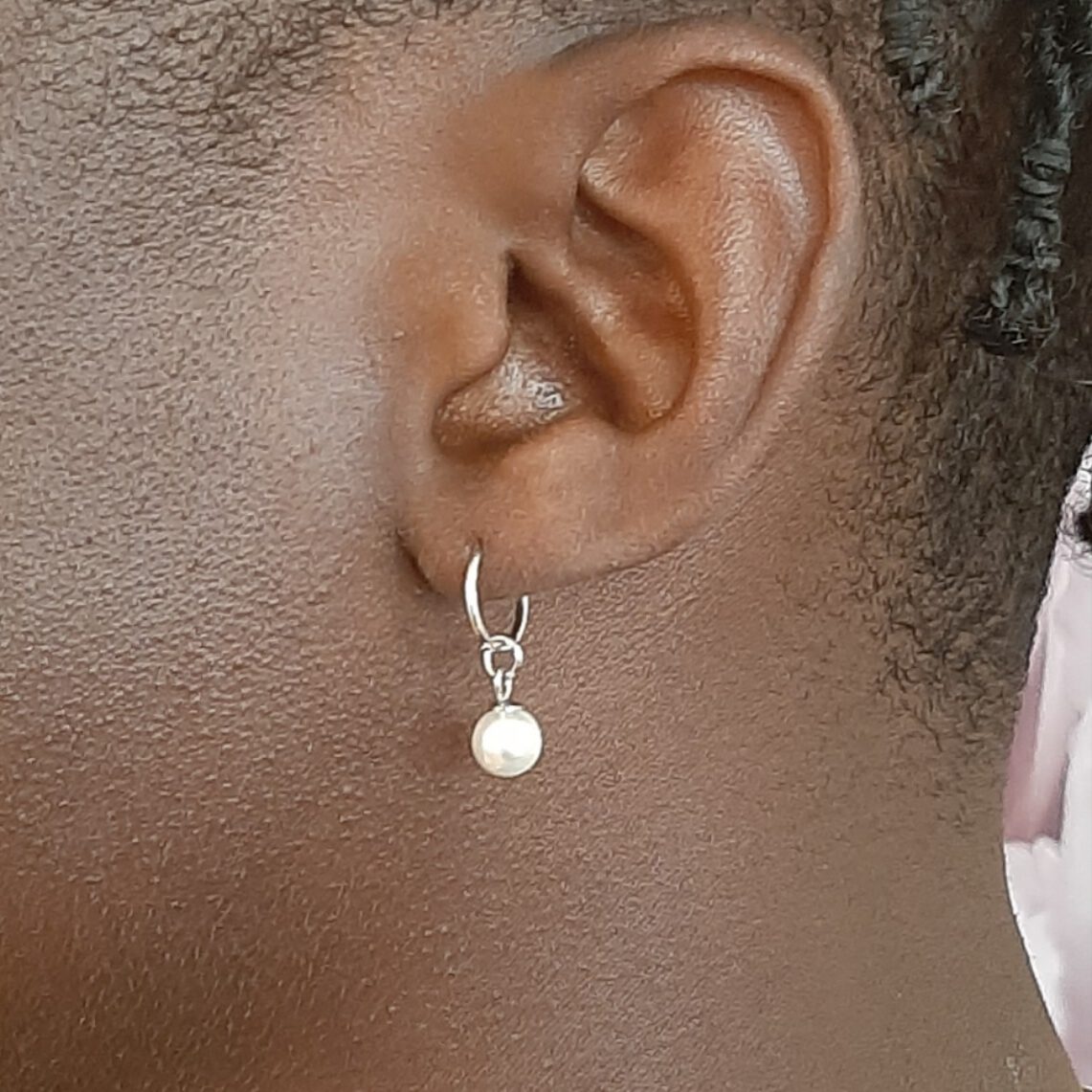 Schmuckstyling von Miri. Perlenohrring in weißgold in Lobe. Dieser filigrane Perlenanhänger wurde zusammen mit einem weißgoldenen Ring in ein Lobe- Piercing in unserem Studio eingesetzt.