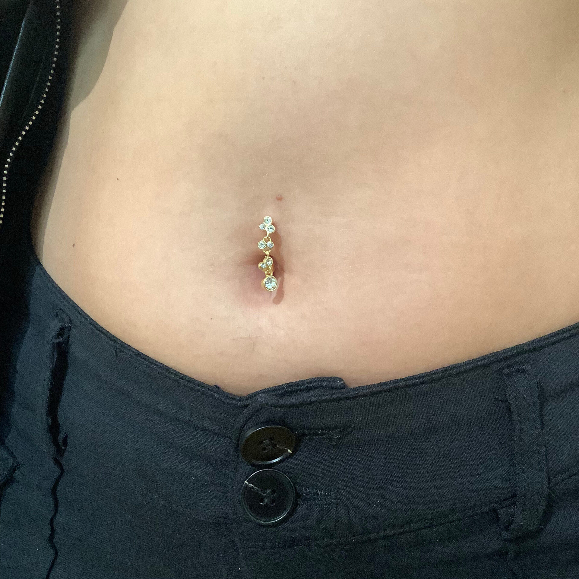 Schmuckstyling von Miri. Gold kristallener Piercingschmuck in Bauchnabelpiercing. Dieser tolle gold- glitzernde Schmuck wurde von uns im Studio in ein Bauchnabelpiercing eingesetzt.